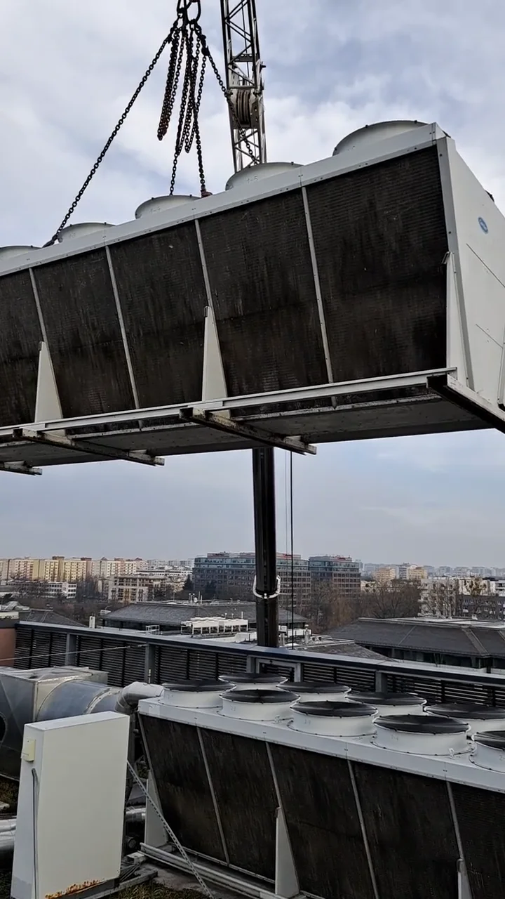 Chiller Carrier podnoszony dużym dźwigiem podczas montażu lub demontażu