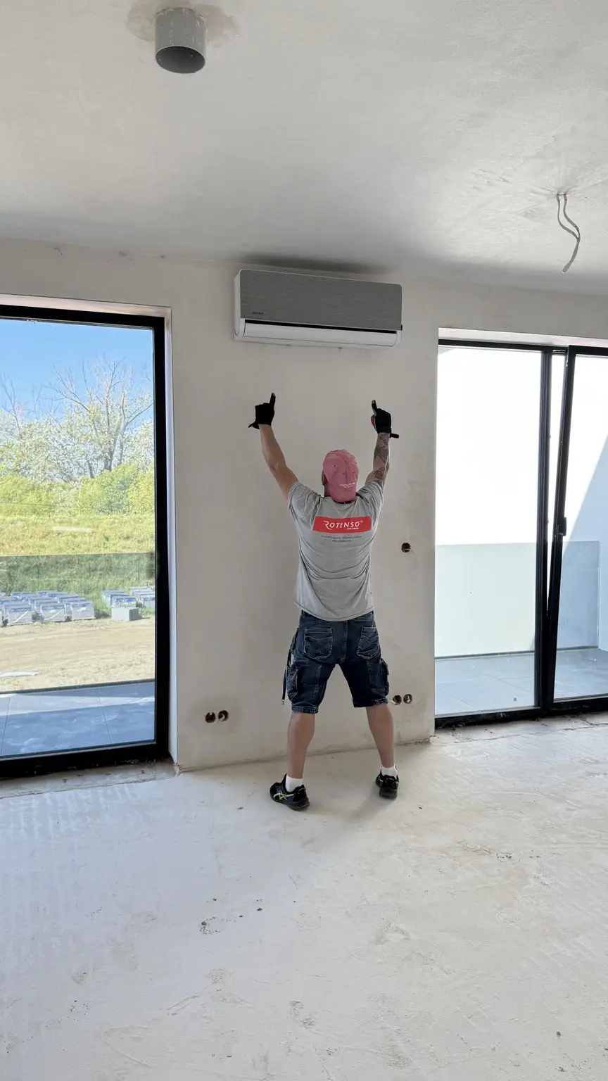 Instalator Profair pokazuje gotową jednostkę wewnętrzną klimatyzatora Rotenso zamontowaną na ścianie
